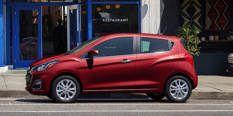 Red Spark Car parked front of restaurant left side view