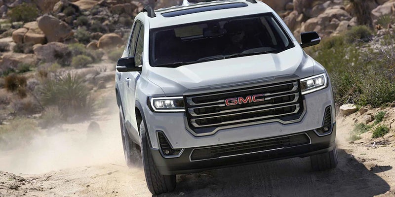 A white Acadia off roading front view
