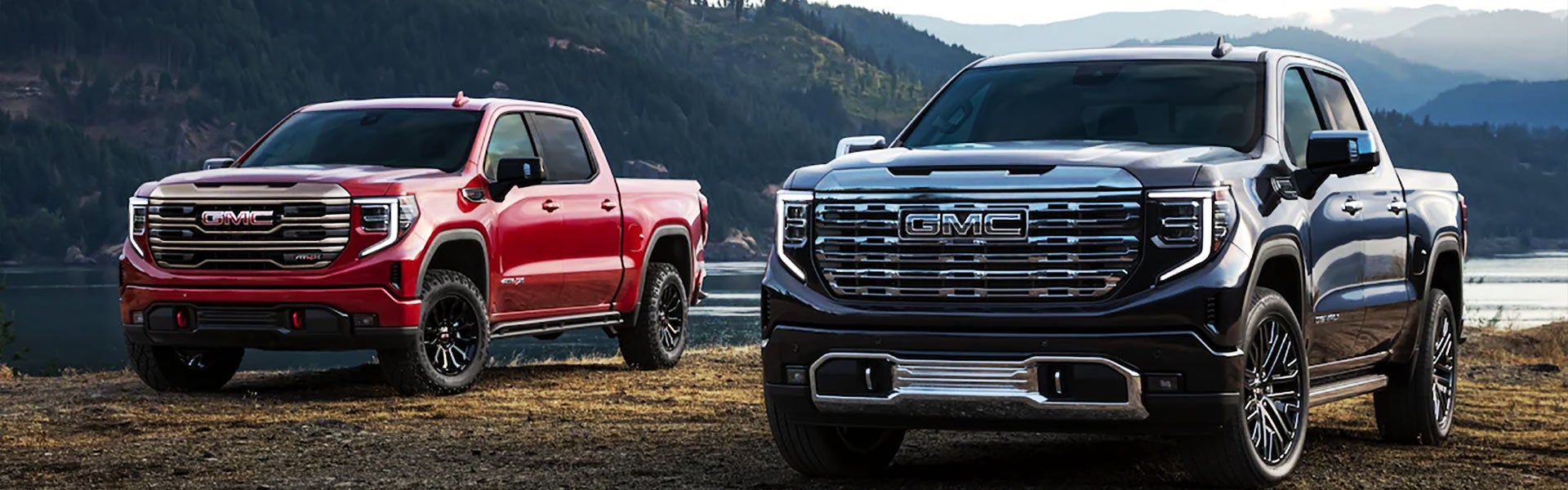 A Red and black Sierra trucks stands near lake